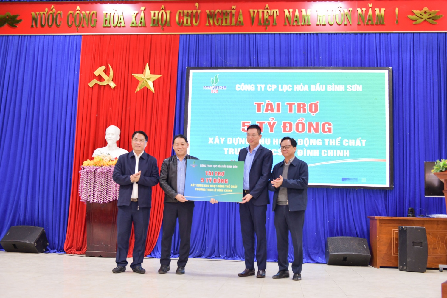 Ông Nguyễn Văn Hội – Thành viên HĐQT (ngoài cũng bên trái) và ông Mai Tuấn Đạt – Phó Tổng Giám đốc BSR (thứ 2 từ phải qua) tặng biển tượng trưng hỗ trợ cho Trường THCS Lê Trung Chinh (huyện Thăng Bình, Quảng Nam).