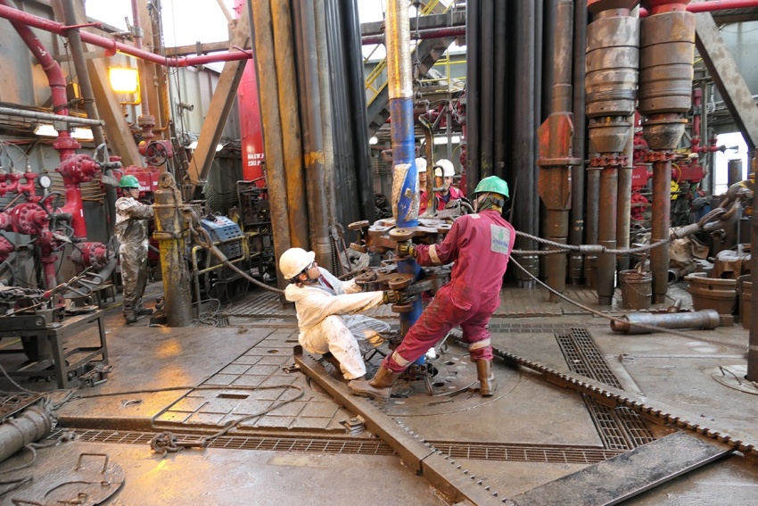 Các công nhân đang thay cần khoan, một trong những công việc nặng nhọc và vất vả nhất trong nghề khoan thăm dò.