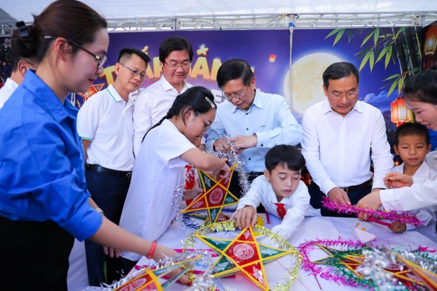Các đại biểu trong đoàn công tác cùng các em học sinh trải nghiệm hoạt động làm đèn ông sao.